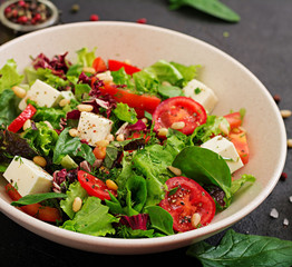 Dietary salad with tomatoes, feta, lettuce, spinach and pine nuts.