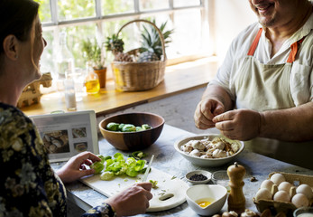 Closeup of people preparing vegetable to be cooked in the kitchen