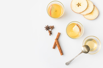 top view of glasses of apple cider with spices isolated on white