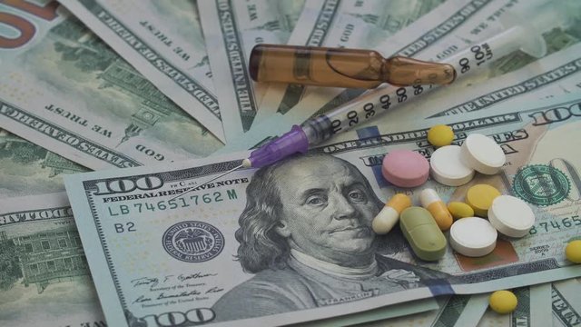 Drugs and pills for addiction lie on the thousands of paper dollars. The frame rotates counterclockwise.
