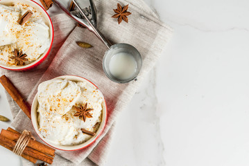 Cold Homemade Eggnog Ice Cream with Cinnamon and anise, on white marble background, copy space