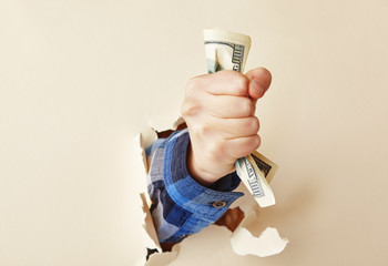 the hand holds a hundred dollar bill