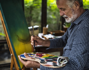 Closeup of artist hand painting artwork at workspace