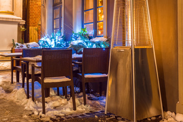Street cafe with fireplace by night in Gdansk in winter time. Poland, Europe.