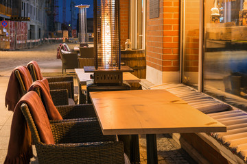 Street cafe with fireplace by night in Gdansk. Poland, Europe.
