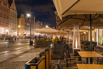 Street cafe with fireplace by night in Gdansk. Poland, Europe.