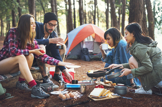 Friends camping in the forest - a group of friends enjoying a picnic in the woods