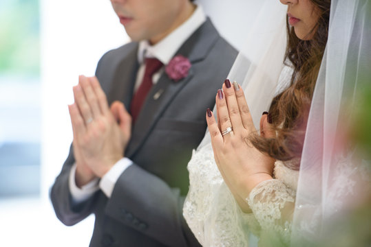 Groom and bride are doing wedding ceremony.