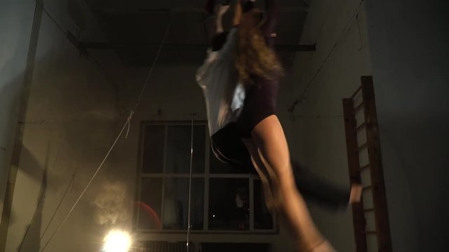 Man and woman are swinging in the air and hanging upside down, slow motion
