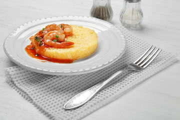 Plate with fresh tasty shrimp and grits on white wooden table