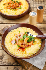 Plate with fresh tasty shrimp and grits on wooden table