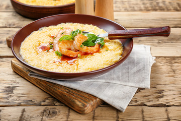 Plate with fresh tasty shrimp and grits on wooden table