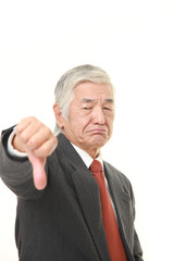 senior Japanese businessman with thumbs down gesture