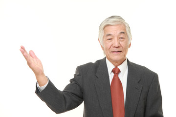 senior Japanese businessman presenting and showing something