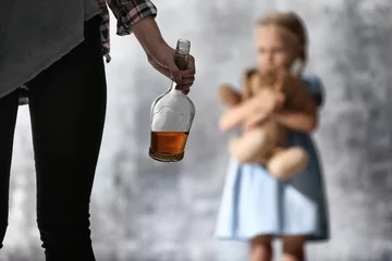 Foto op Plexiglas Vrouw met fles alcohol en wazig meisje op grijze achtergrond © Africa Studio