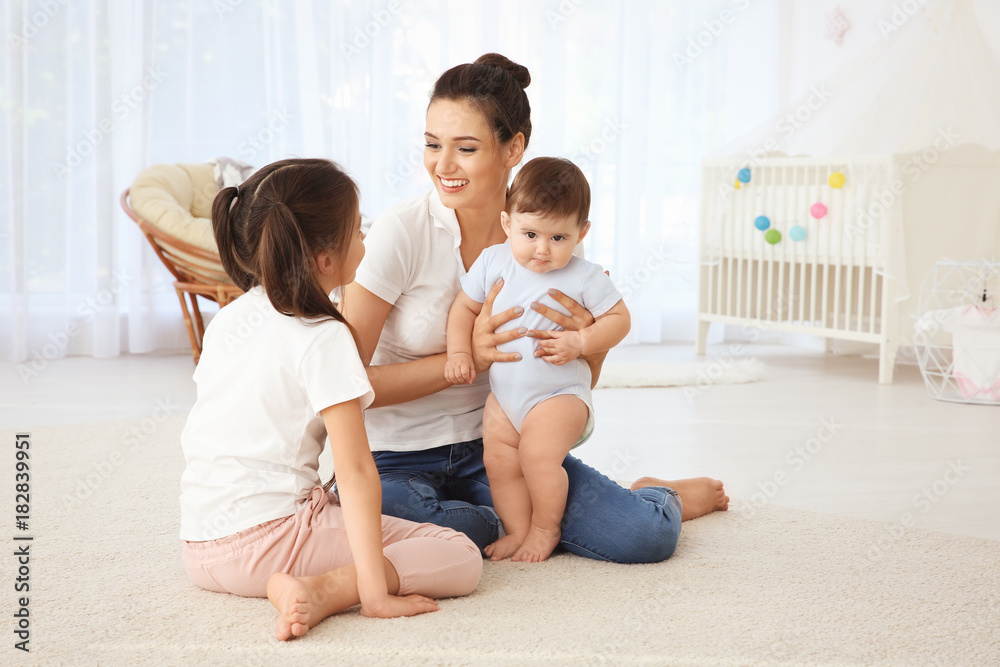 Canvas Prints young mother with cute kids in children room