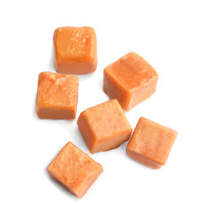 Delicious caramel candies on white background