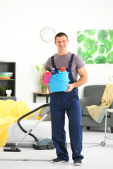 Young man with cleaning supplies at home