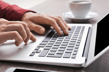 Man using laptop on table, closeup