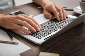 Man using laptop on table, closeup