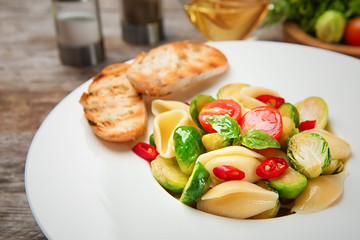 Plate of pasta with Brussels sprouts on table