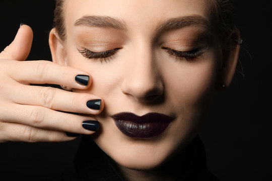 Beautiful woman with stylish make up and long eyelashes on black background