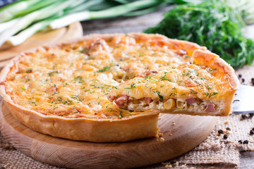 A piece of quiche Lorraine on the table. horizontal