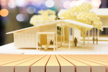 Selective focus of wooden table in front of blur home model. urban, city, home concepts, can used...