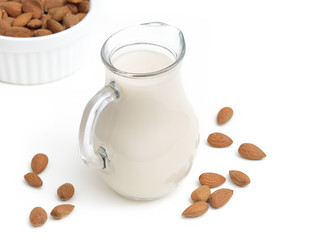 Almond milk isolated on white background with almonds in a bowl