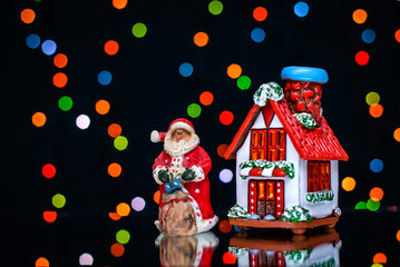 Christmas picture with Santa and house on a background of colored lights