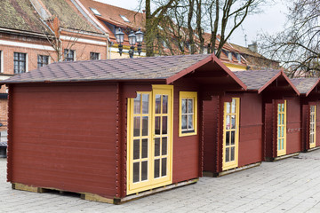 Christmas fair cabins perspective view. A raw of small colored houses on sett square