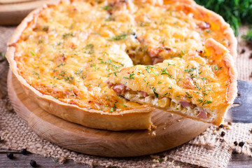 Sliced quiche with cheese and bacon on a cutting board