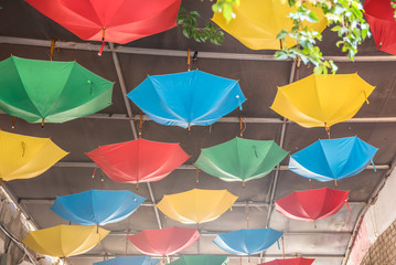 Fototapeta na wymiar Colorful umbrellas hanging above street of Alacati