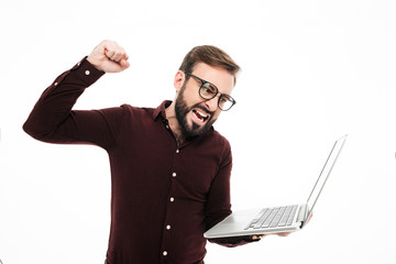 Portrait of a happy bearded man holding laptop computer