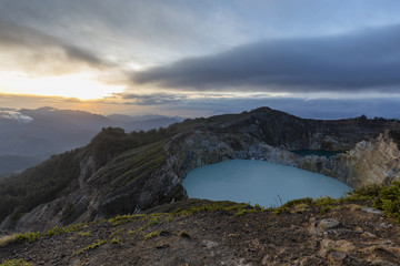 Fog begins to form as the sun rises over two crater lakes at the Kelimutu National Park in East Nusa Tenggara, Indonesia.