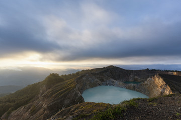 The sun illuminates the edge of Danau Kootainuamuri the middle crater lake at Kelimutu National Park in Indonesia.