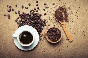 Cup of coffee, bag and scoop on old rusty background