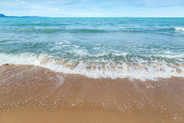 Fototapeta na wymiar Beautiful white soft wave on empty tropical beach and blue sea 