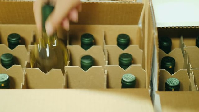 Close-up of putting bottles of wine in a box. Preparation for shipment to the retail sales network