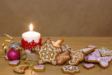 Gingerbread and candle on a wooden table. Background in polka dots.