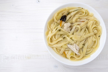 Appetizing chicken soup with noodles, with the addition of potatoes, carrot greens and bay leaf.