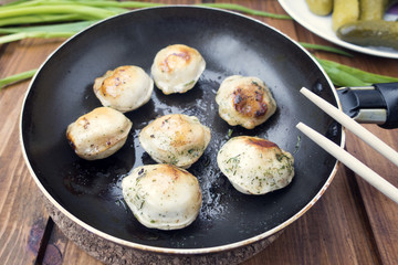 Fried dumplings in a frying pan.