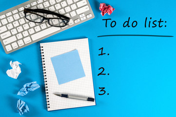 To do list conceptual. Mockup with empty space and workplace with notepad, keyboard at blue background