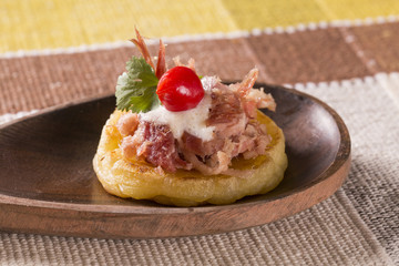 blinis of puba dough, smoked meat, coriander and minced pepper