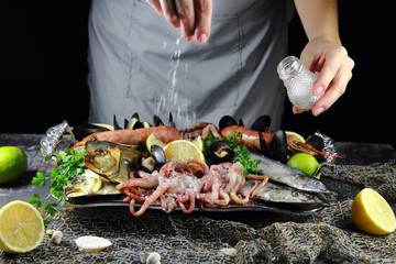девушка посыпает солью блюдо из морепродуктов © lenakorzh