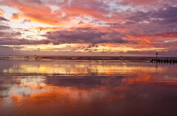Colourful sunrise sky and reflection in sea water