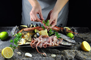 девушка украшает петрушкой блюдо с морепродуктами © lenakorzh