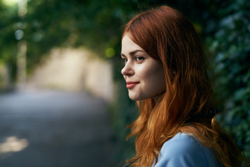 Beautiful young woman in blue dress walking along the street in the city