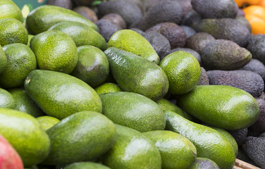 Background of ripe avocado on the market stalls shot close-up