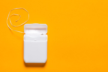 Dental floss on yellow background